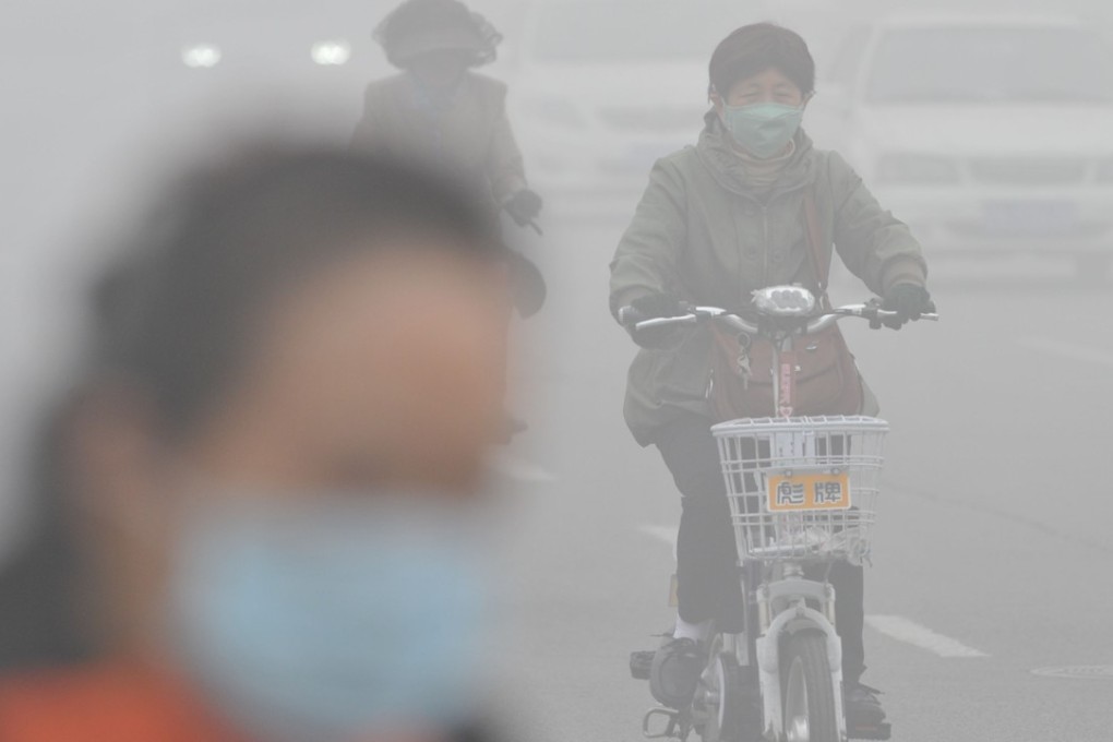 A woman wearing a mask rides in smog-shrouded Tianjin in northern China. Photo: Xinhua