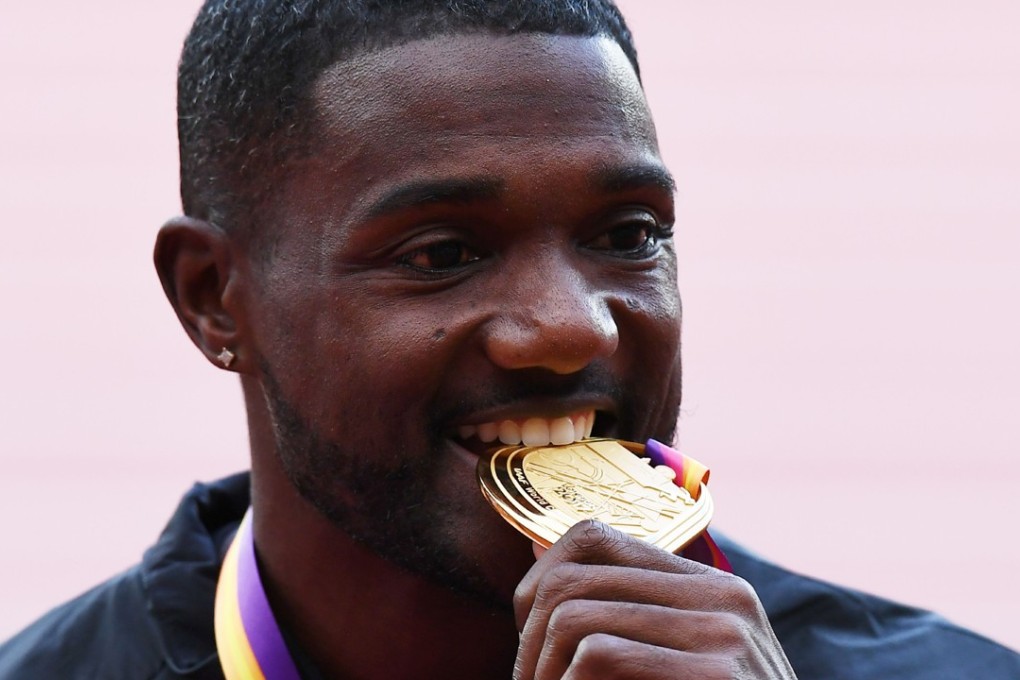 Justin Gatlin poses on the podium during the victory ceremony. Photo: AFP