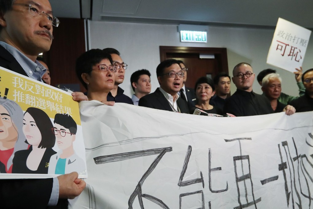 Pan-democratic lawmakers stage a protest against the disqualification of four of their Legco peers. Photo: Edward Wong