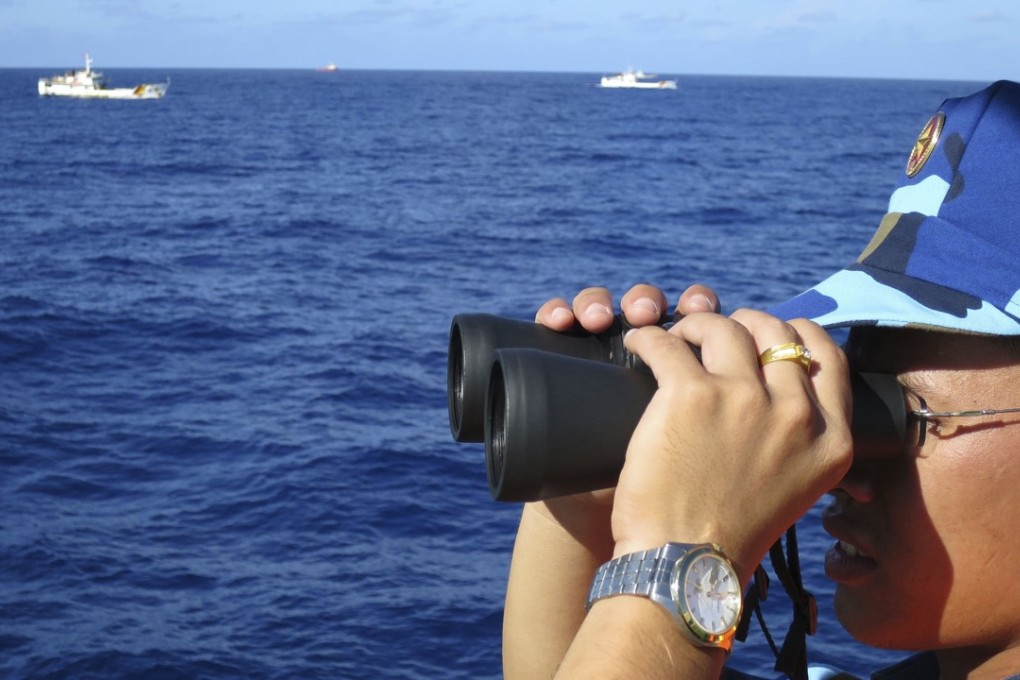 A crewman from a Vietnamese coastguard ship observes as Chinese coastguard vessels chase Vietnamese ships in the South China Sea. Photo: Reuters