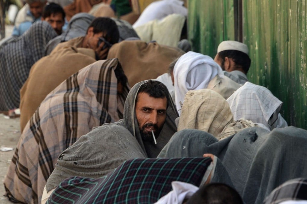 Afghan drug addicts smoking heroin on a street in Jalalabad. Photo: AFP