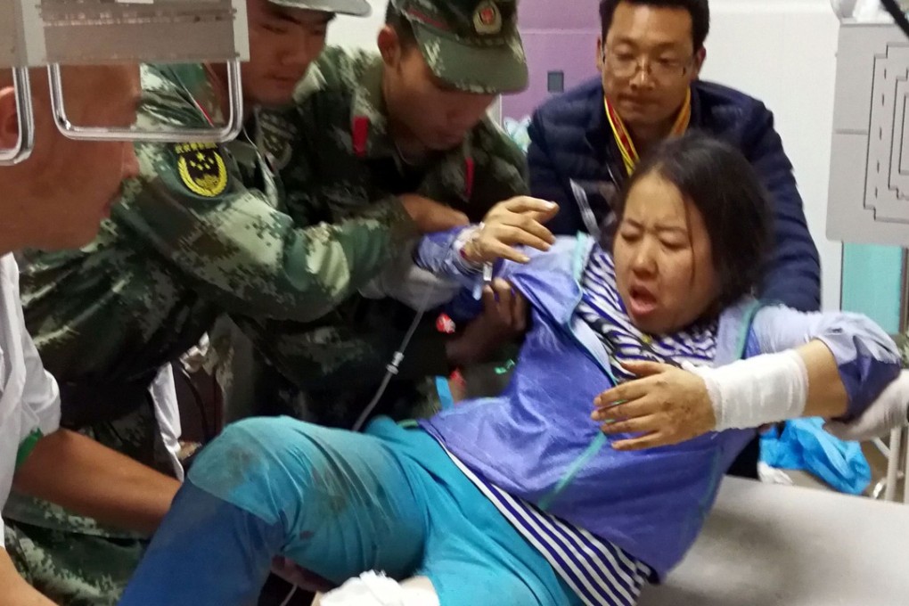 Paramilitary police help a doctor move a woman, injured during an earthquake, at Jiuzhaigou County Hospital in Jiuzhaigou in southwest China's Sichuan province. Photo: AFP