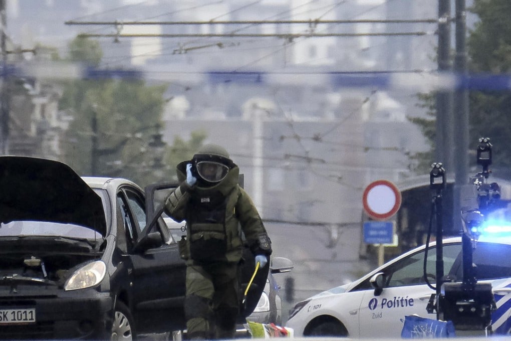 A member of the DOVO - SEDEE, bomb disposal inspects a suspect car with a German number plate following a high-speed chase when the vehicle did not stop at a red light in the Molenbeek area of Brussels on August 8, 2017. Photo: AFP