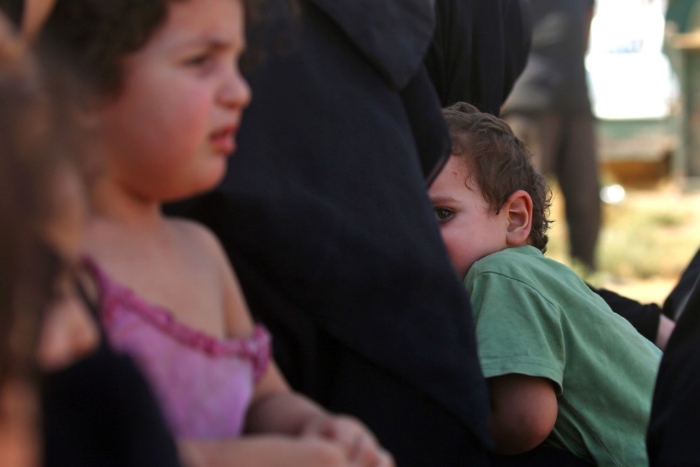A displaced child who fled from the Islamic State (IS) group's stronghold of Raqa embraces a woman upon arrival at the village of Hawi al-Hawa, less than two kilometres (one mile) outside the city, on August 8, 2017. Photo: AFP