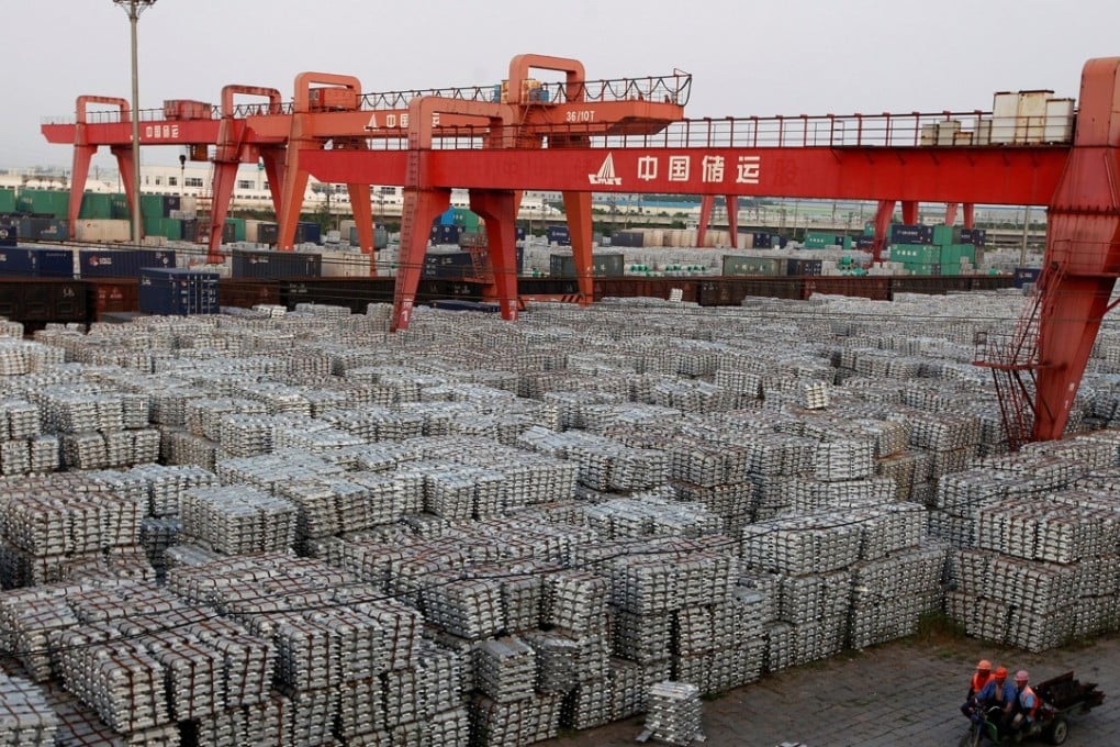 Workers ride on an motor rickshaw through an aluminium ingots depot in Wuxi, Jiangsu province, China. Photo: Reuters