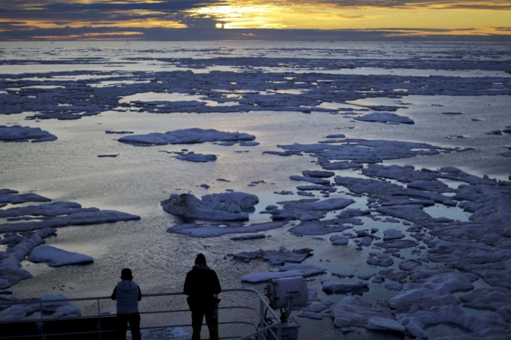 Researchers on a Finnish icebreaker watch the sun set over sea ice floating in the Canadian Arctic Archipelago last month. Sea ice plays an important role in the global climate system by cooling the surrounding water and air. Photo: AP