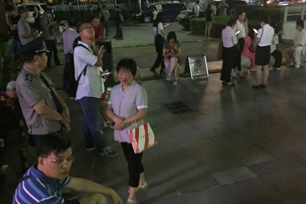 People stand outside in Xian, central China’s Shanxi province, on Tuesday. They evacuated their buildings after being alerted to the earthquake in Sichuan via the country’s early warning system. Photo: AFP