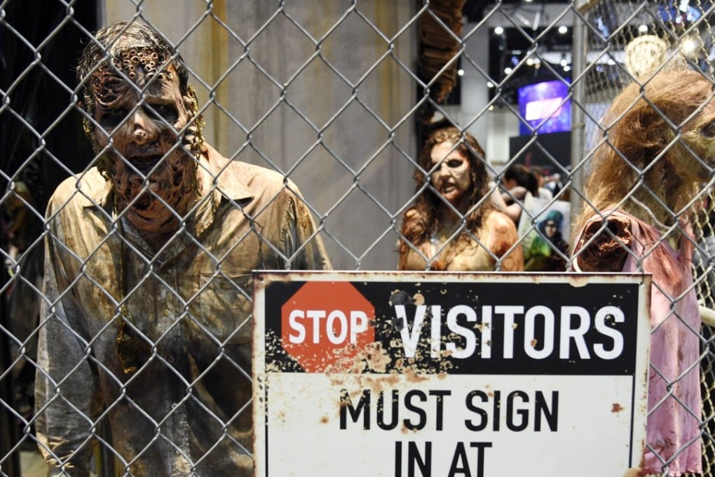 Zombie characters walk inside a cage at the "Walking Dead" exhibit on the convention show floor during Preview Night of the 2017 Comic-Con International show in July in San Diego. Photo: AP