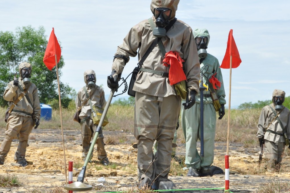 Soldiers in protective gear search for unexploded ordnance at the central Vietnamese city of Danang’s airport. Photo: AFP