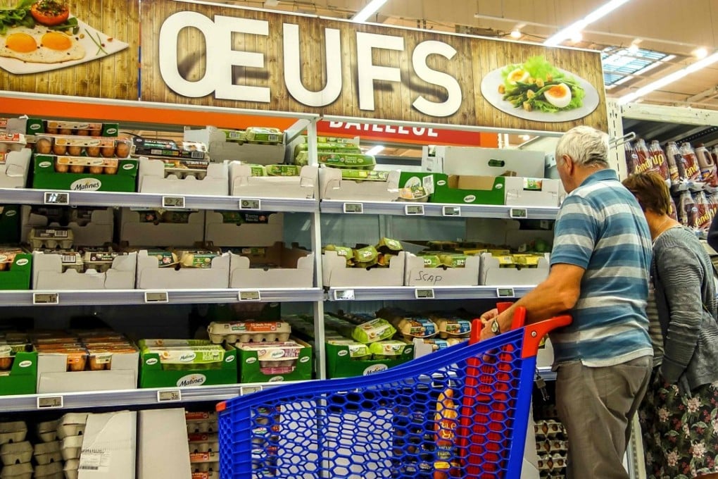 People stand in front of eggs displayed at a supermarket in Lille, on August 11, 2017, as an eggs scandal spreads across Europe. Nearly 250,000 insecticide-contaminated eggs have been sold in France since April, but the risk for consumers is “very low,” French Agriculture Minister Stephane Travert said on Friday. Photo: AFP