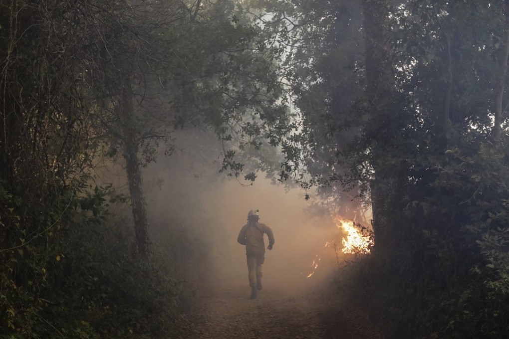 A fireman works at the scene of a forest fire near the village of Cioga do Campo, Cantanhede, Coimbra, Portugal. Photo: EPA