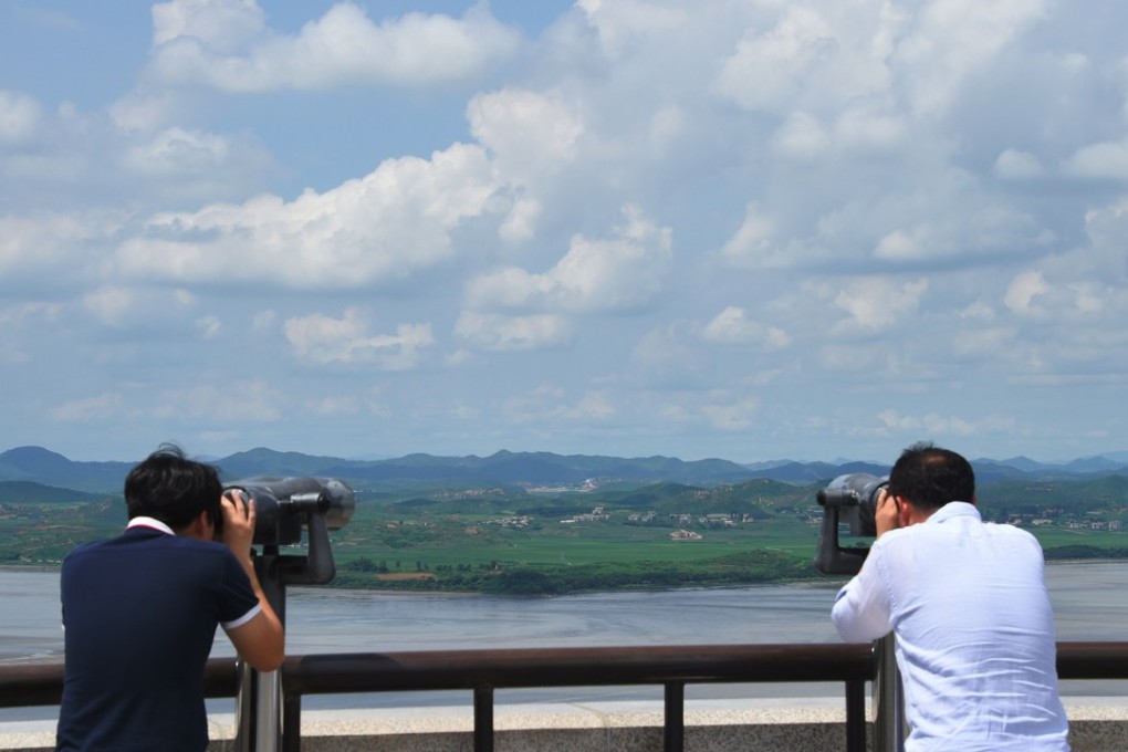 Visitors look through binoculars towards North Korea from a South Korean observation post in Paju, near the demilitarised zone dividing the two Koreas, on August 11. Photo: AFP