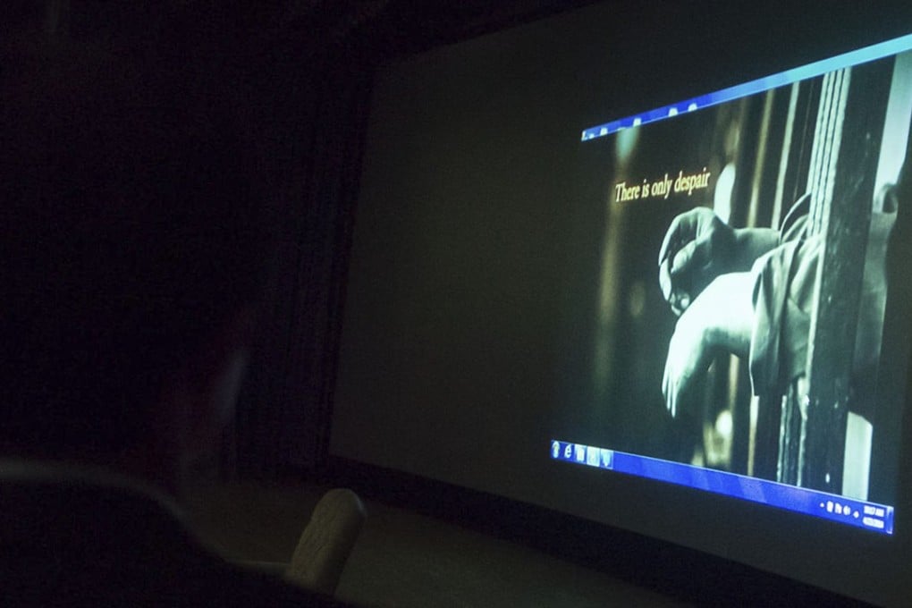 North Korean escapee Shin Dong-hyuk (left) watches a video about prison camps in his country during a presentation in South Korea in 2014. Photo: Alamy Stock Photo