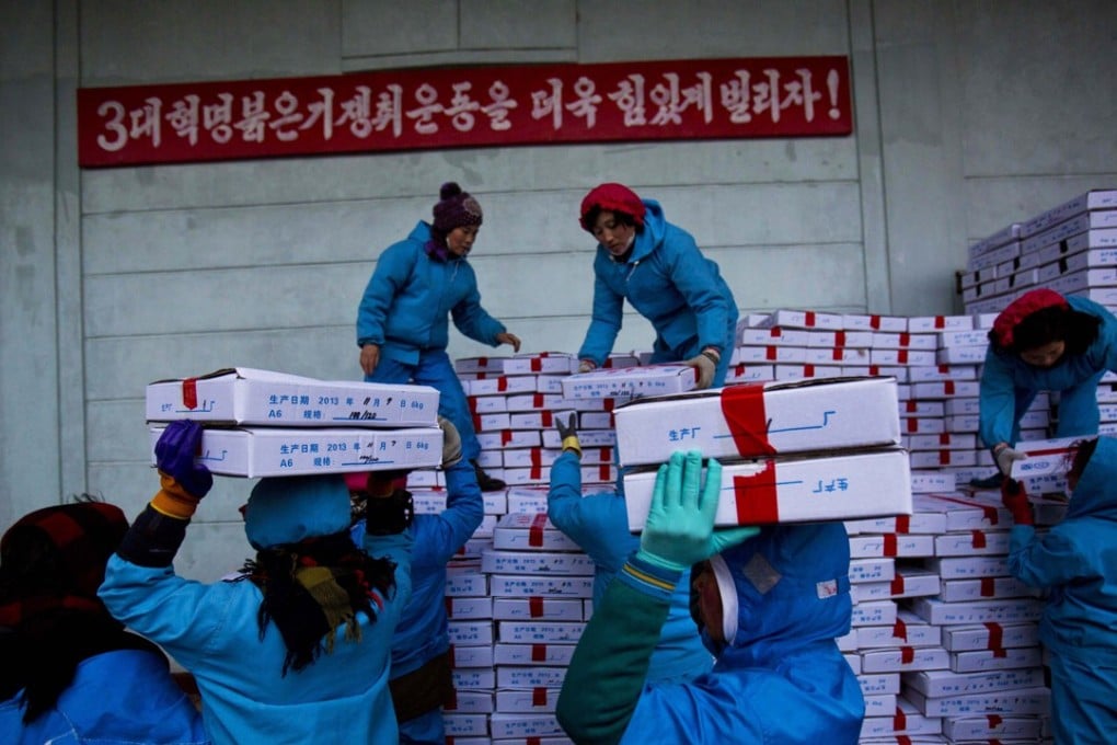 North Korean workers carry boxes of seafood as they load a Chinese transport truck at the Suchae Bong Corp seafood factory in Rajin, North Korea. Jessica Bartlett, a senior associate at Freshfields Bruckhaus Deringer based in Hong Kong. says since the vast amount of trade between the countries is conducted in dollars, that would make it near impossible for many Chinese banks to do business if sanctions get tougher.