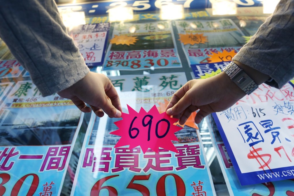 An estate agent from Cheong Shing Property in Quarry Bay updates a property price at the shop. Photo: SCMP