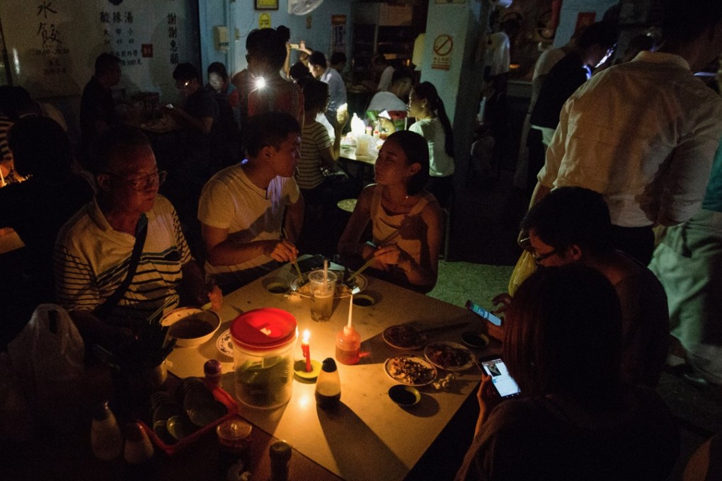 People dine in darkness during the blackout in Taipei City, Taiwan. Photo: Eason Lam/SCMP