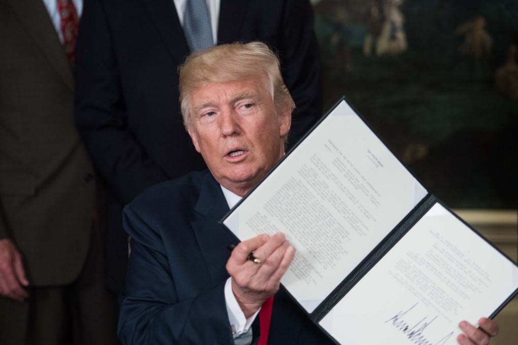 Donald Trump shows off the memorandum he signed to start an investigation into China’s policies. Photo: AFP