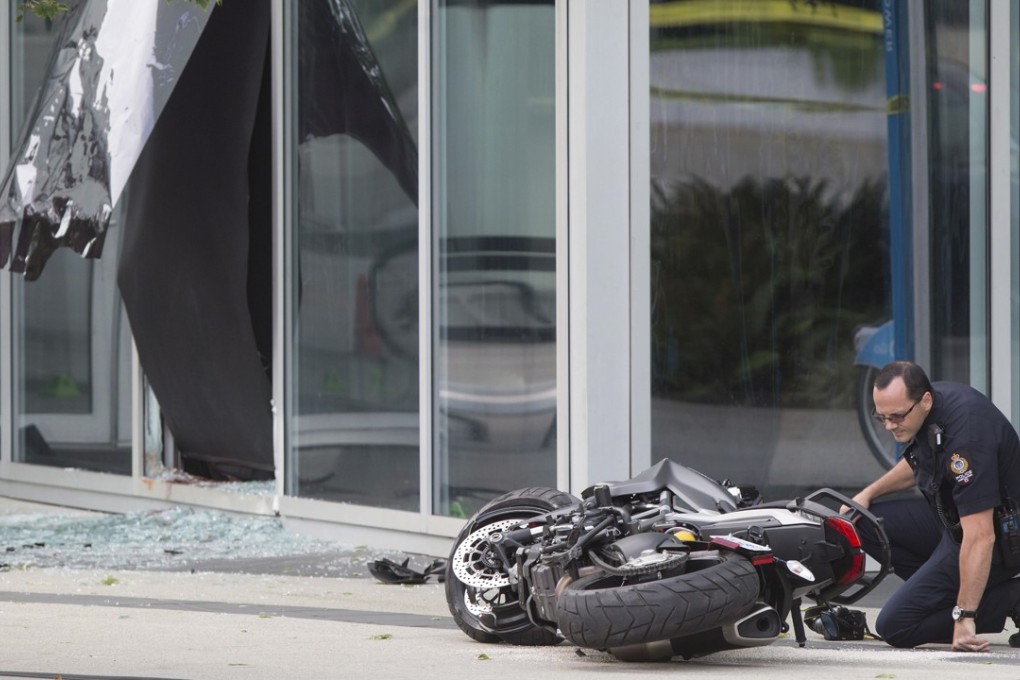 A police officer examines a motorcycle after a woman stunt driver working on the movie Deadpool 2 died after a crash on set, in Vancouver, on Monday. Vancouver police said the driver was on a motorcycle when the crash occurred on the movie set. Photo: The Canadian Press via AP