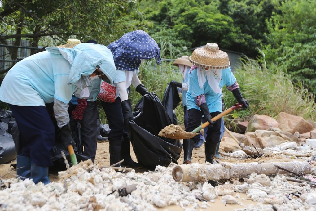 Workers cleaning up palm oil on Lamma Island. Photo: Xiaomei Chen