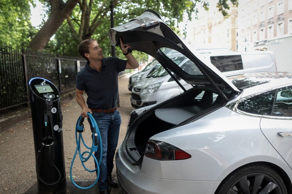 A driver removes a charging cable to connect his Tesla Model S to a charging station in London. The UK government plans to invest more than 800 million pounds ($1 billion) in new driverless and zero-emission vehicle technology as it seeks to boost its economy while leaving the European Union. Photo: Bloomberg