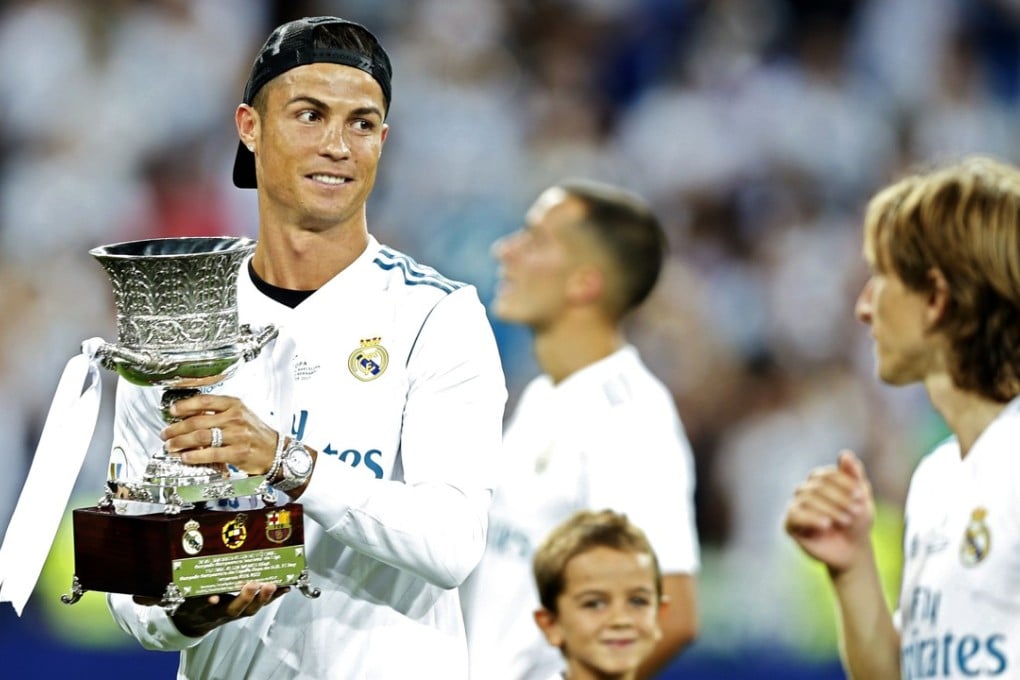 Cristiano Ronaldo holds the trophy while celebrating with teammates after Real Madrid win the Spanish Super Cup. Photo: AP