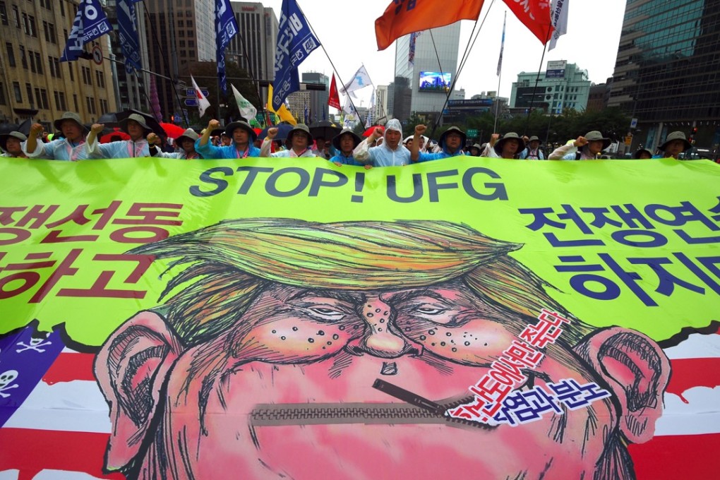 South Korean protesters carry a caricature of US President Donald Trump towards the US embassy in Seoul. Photo: AFP