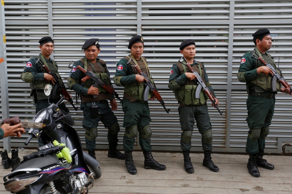 Cambodia police stand at a condo where they arrested dozens of young Chinese men and women. Photo: Reuters