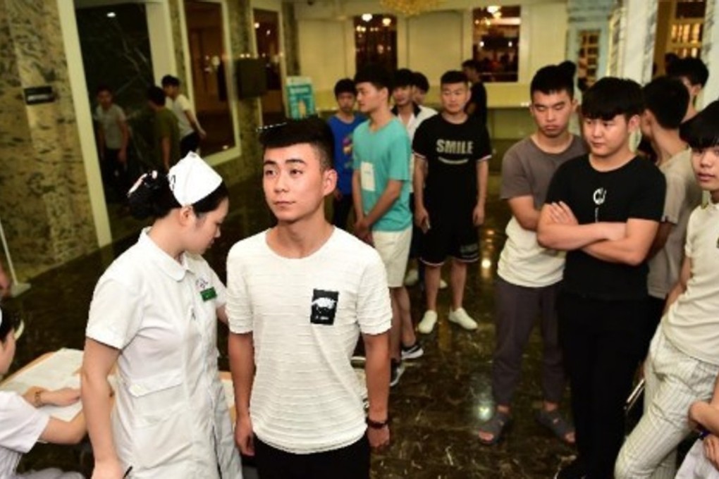 PLA recruits in Hefei, Anhui province, wait for a physical exam. Applicants are falling short in a range of areas from eyesight to weight. Photo: Xinhua