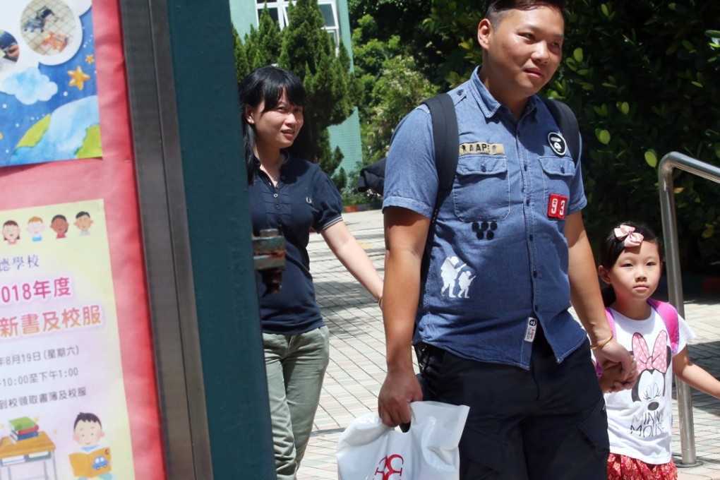 Parents and students collect uniforms and new textbooks for the coming year at Hing Tak School in Tuen Mun. Photo: David Wong