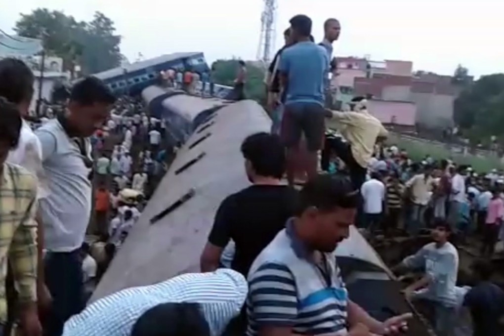 Passengers on the roof of a train after part of it derailed, in Khatauli, northern India. Photo: AP