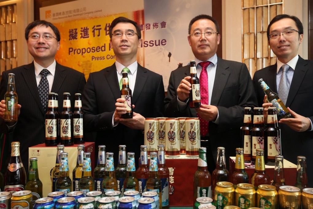 China Resources Beer executives pose with samples of the company’s product. Photo: K. Y. Cheng