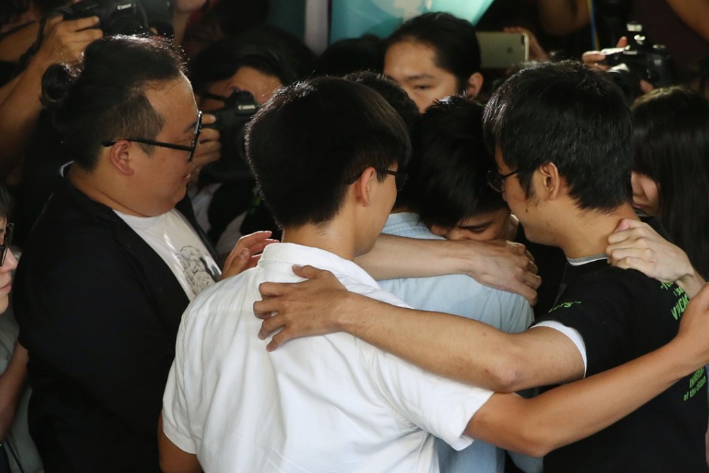 Joshua Wong, Nathan Law, Alex Chow and Lester Shum embrace outside the High Court. Photo: Sam Tsang
