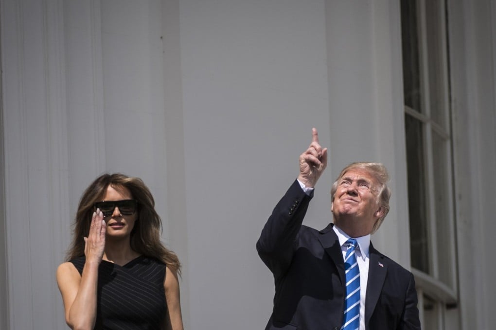 President Donald Trump gazes up toward the solar eclipse, with first lady Melania Trump by his side, from a balcony at the White House. Photo: Washington Post / Jabin Botsford.
