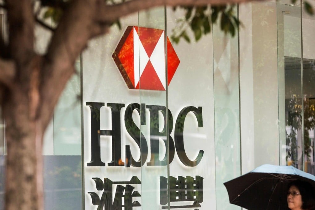 A pedestrian walks past HSBC signage in the Admiralty district of Hong Kong. The US said that possibly up to 11 bank employees may be involved in a foreign exchange front-running scheme aside from the two facing charges over the matter. Photo: AFP
