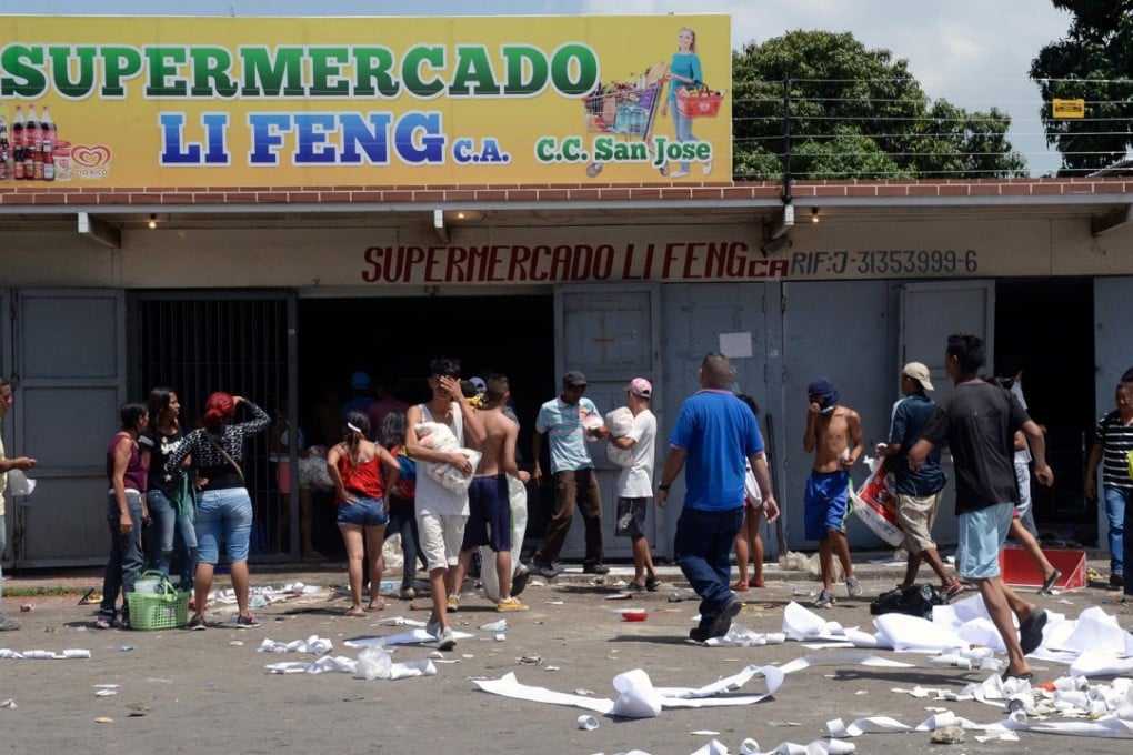 People loot a supermarket in Maracay, Venezuela, on June 27. Photo: AFP