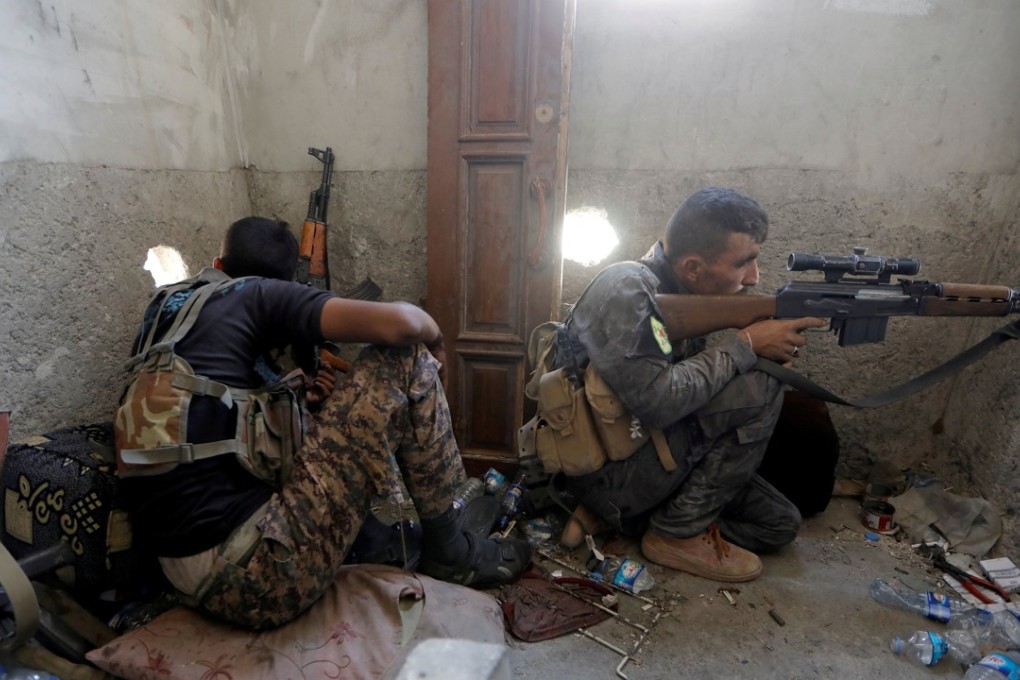 A sniper of the Syrian Democratic Forces aims his weapon during the fighting with Islamic State's fighters in the old city of Raqqa, Syria. Photo: Reuters