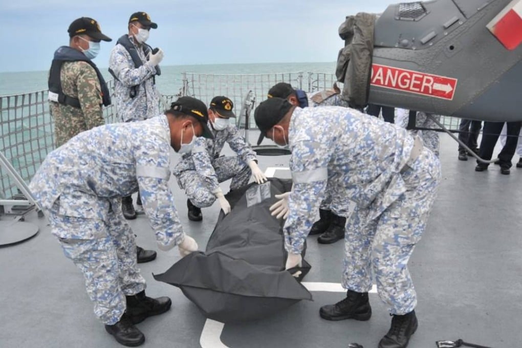 Royal Malaysian Navy personnel move a body bag containing the remains of one of the missing sailors from the USS John S McCain. Photo: Handout