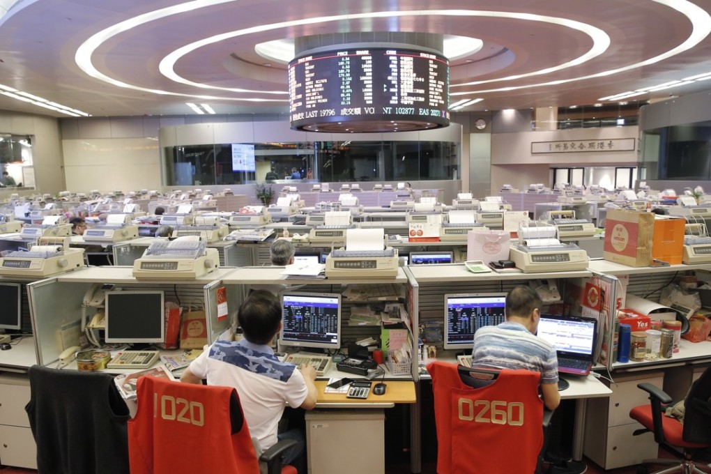 Floor traders monitor stock prices at the Hong Kong Stock Exchange in 2016. Trading was suspended all of Wednesday as Typhoon Hato battered the city. Photo: AP