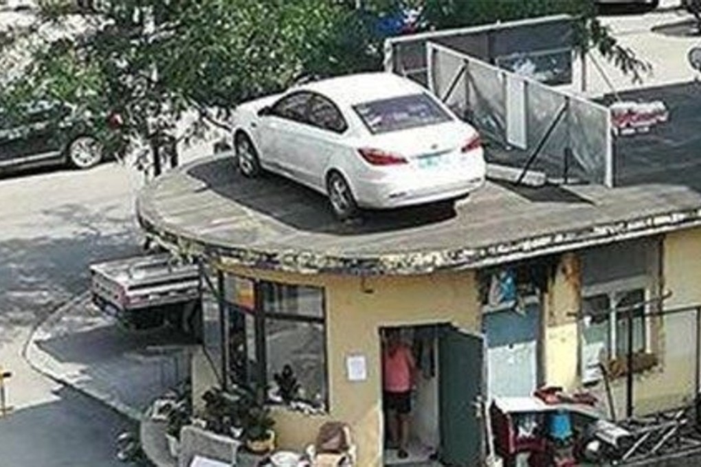 The car was left on the roof of the security station after the dispute between its driver and the residential estate’s security guards. Photo: Handout