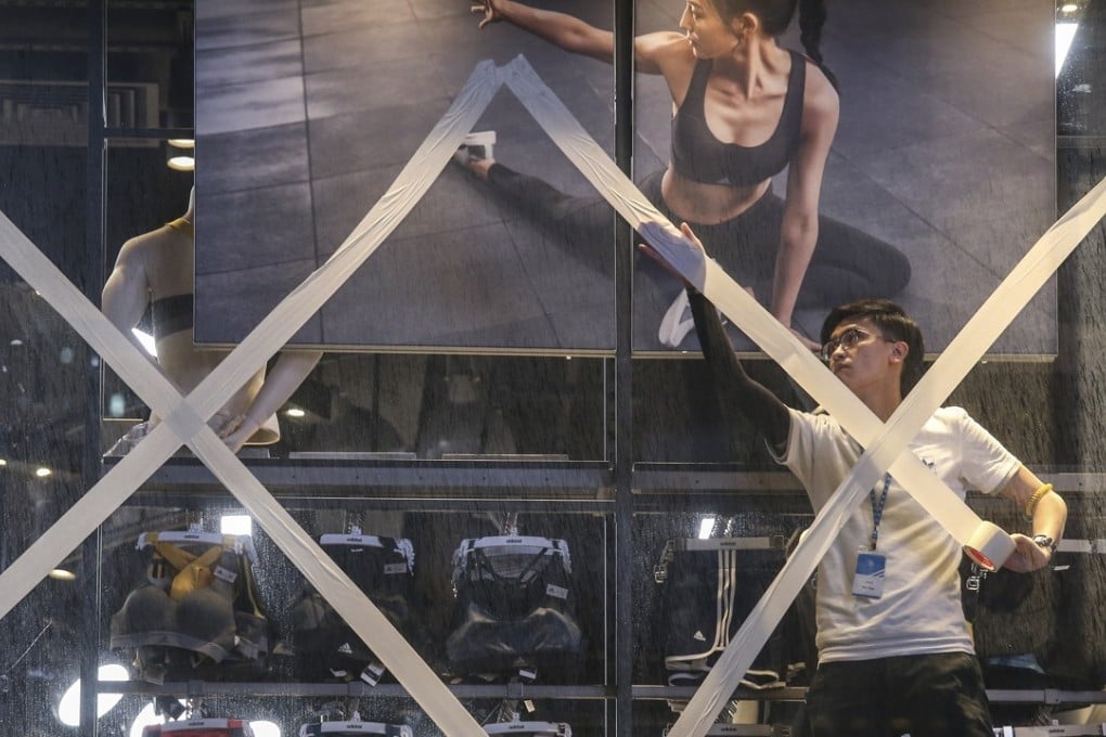 Staff at a gym in Central prepare their premises last night as Typhoon Hato roared towards the city, with the storm likely to be at its closest to Hong Kong this morning. Photo: K.Y. Cheng