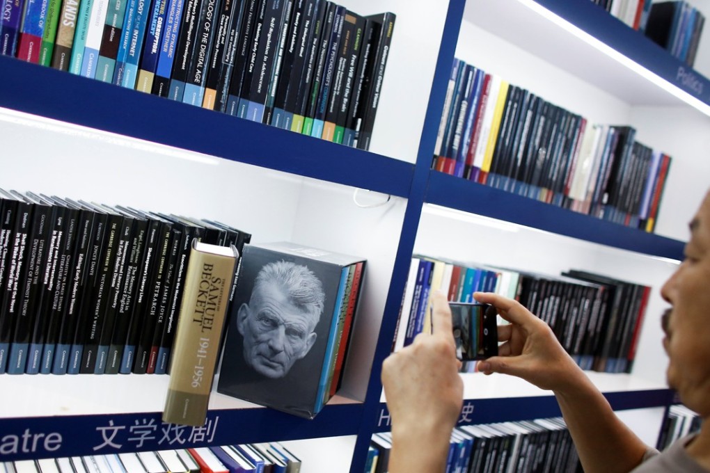A man takes pictures of a collection of writings by Samuel Beckett at the Cambridge University Press stall at the Beijing International Book Fair in Beijing on August 23, 2017. Photo: Reuters
