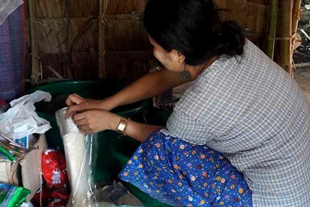 Myanmar woman May Khine Oo, 30, in front of her family's grocery store in Mon State, Myanmar. Photo: Reuters