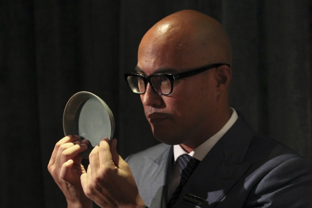 Sotheby’s Nicolas Chow holds up the rare brush washer from the imperial Ru kiln of the Northern Song dynasty. Photo: James Wendlinger