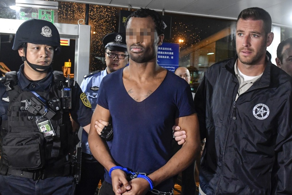 Naquan Ferguson (centre) flanked by Chinese police and a US official at Guangzhou’s international airport. Photo: China News Service