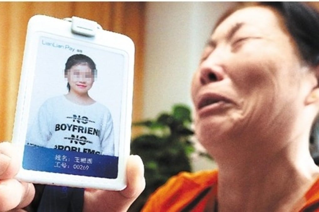 The woman’s family member with a photo of the woman who died after she fell off a building in Hangzhou, Zhejiang province. Photo: Handout