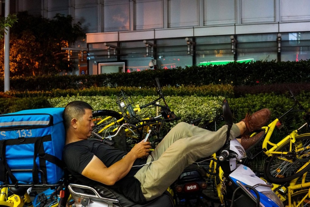 A food delivery driver waits for orders in Shanghai. Photo: AFP