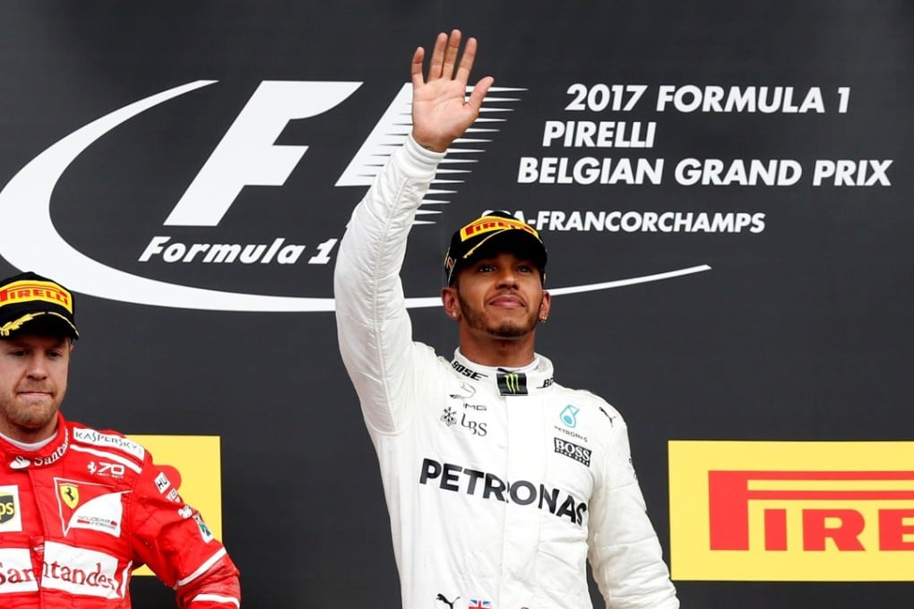 Mercedes’ Lewis Hamilton celebrates on the podium beside a glum Sebastian Vetel after winning the Belgian Grand Prix. Photo: Reuters