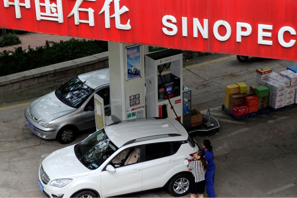 A customer fuels up with petrol at a Sinopec filling station in Qingdao, Shandong province. Photo: Reuters
