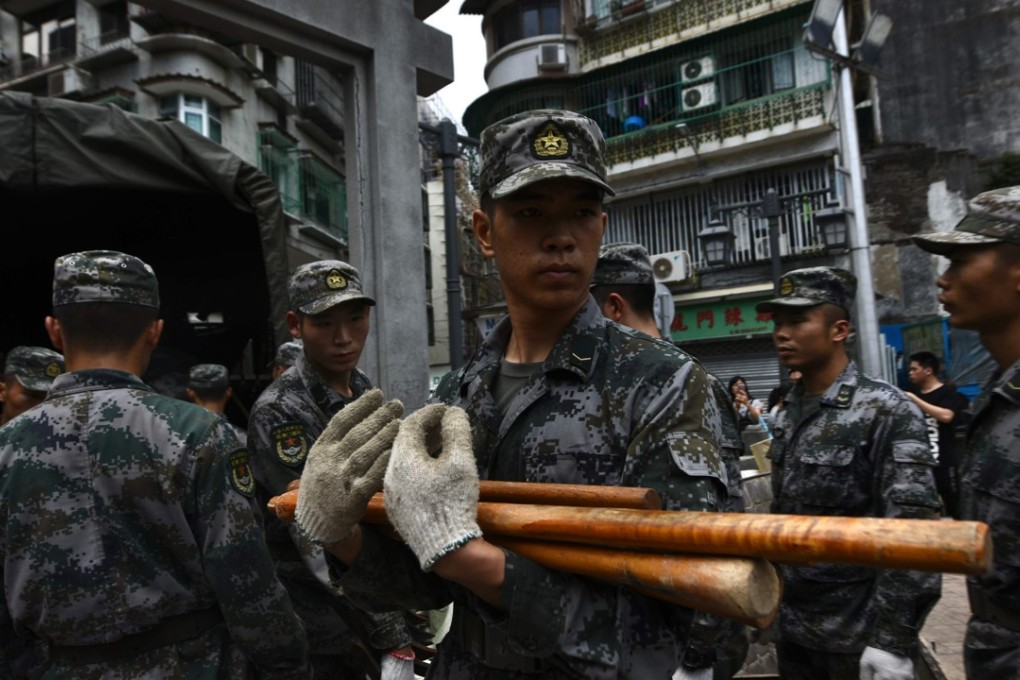 Chinese soldiers based in Macau unload tools as they help clear debris in the city on Friday. Photo: AFP
