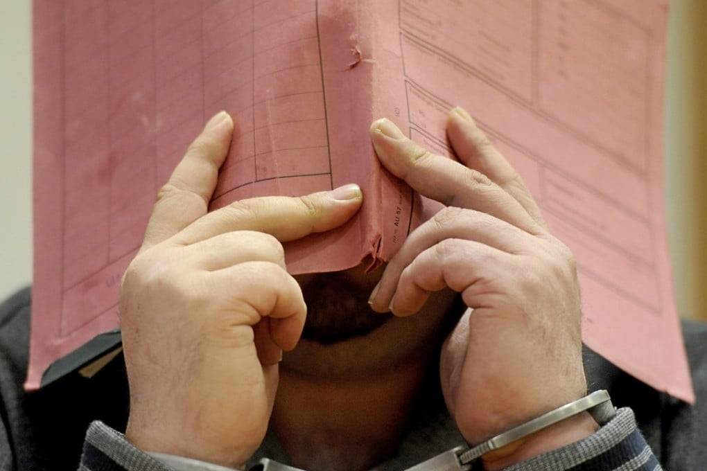 Nurse Niels Hoegel covers his face while on trial in 2015. Photo: AP